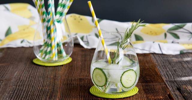 Gin glass filled with a cucumber gin and tonic on a wooden table 