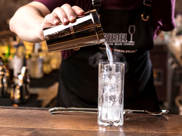 bartender showcasing cocktail in RIEDEL glass