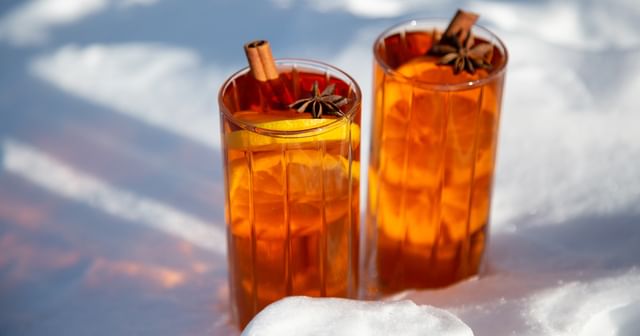 two cocktails with lemon and cinammon in snow