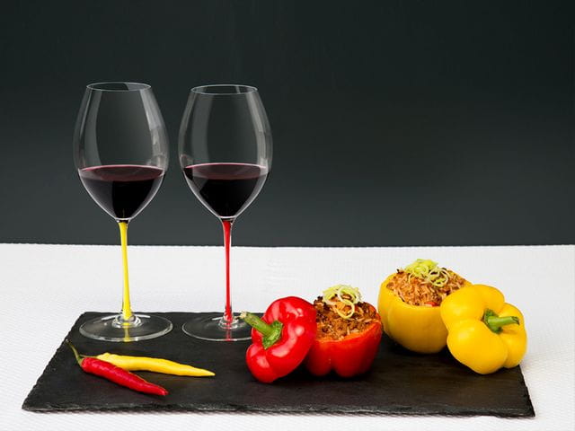 Two RIEDEL Fatto A Mano glasses on a chopping board with capsicum and chillis.