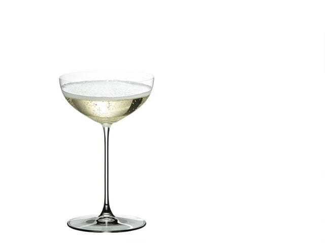 RIEDEL Veritas Coupe filled with Champagne on a white background.