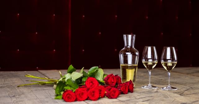 decanter and wine glasses next to roses