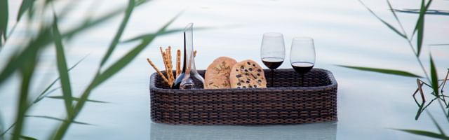floating basket with decanter, cookies and red wine glasses
