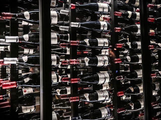 Wine bottles stored on a shelf.