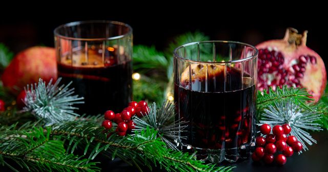 mulled wine in a RIEDEL Drink Specific Double Rocks Glass in the background is a pomegranate and fir branches