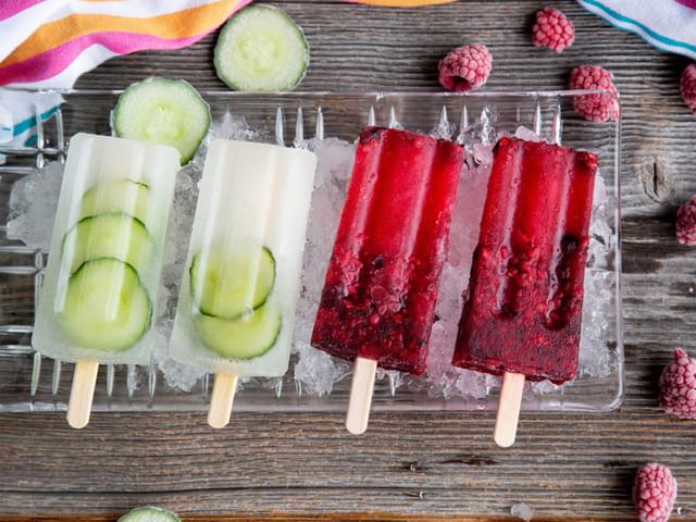 Four gin & tonic iceblocks on a plate over ice.