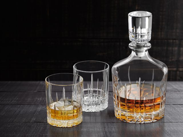 The with Whisky filled SPIEGELAU Perfect Serve Collection decanter next to two Perfect tumblers, one filled with Whisky on the rocks.<br/>