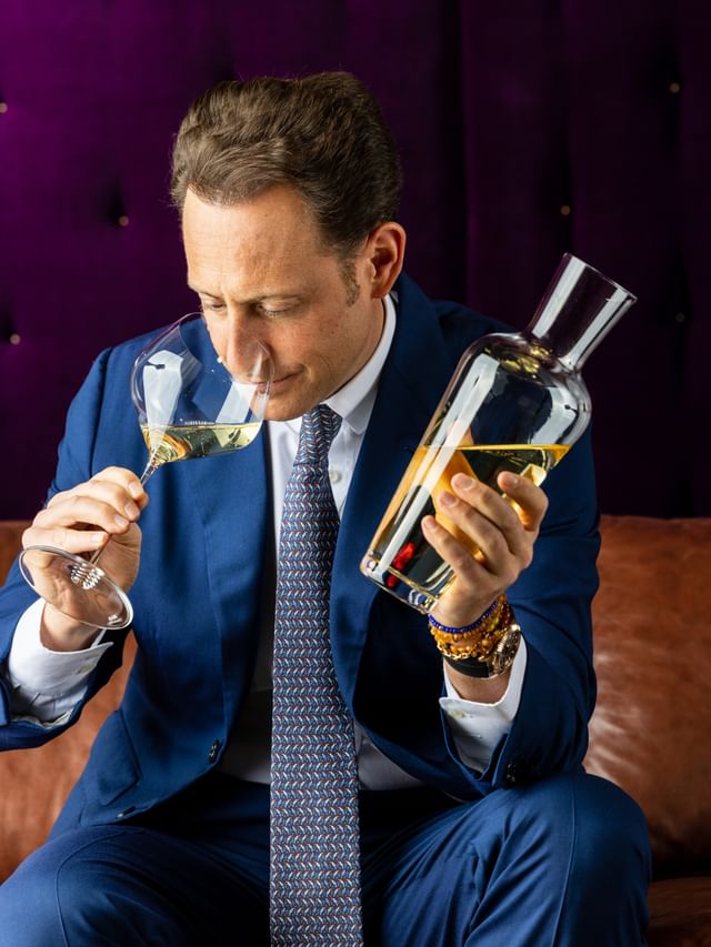 man smelling wine aroma and holding decanter