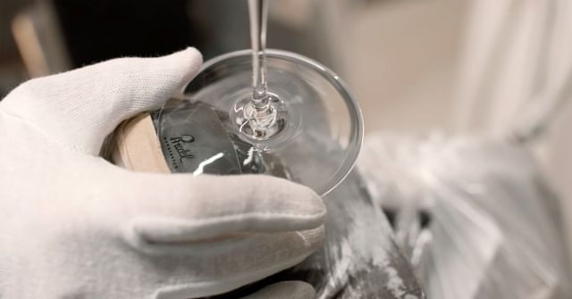 A gloved hand carefully polishes the base of a handmade RIEDEL wine glass, highlighting the precision, craftsmanship, and elegance of the RIEDEL Manufaktur collection.